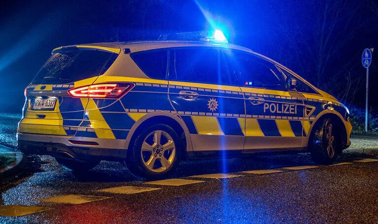 Streifenwagen bei Nacht mit Blaulicht